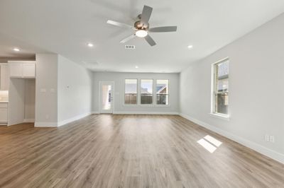 Unfurnished living room featuring light hardwood / wood-style flooring and ceiling fan | Image 2