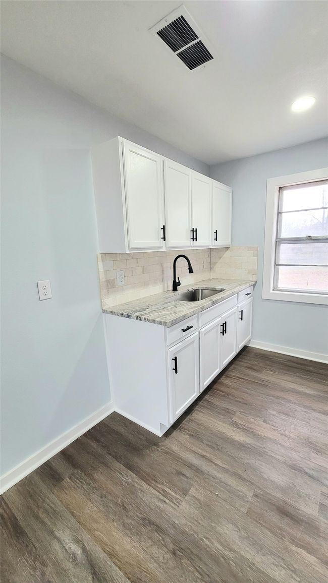 Kitchen with dark wood-type flooring, visible vents, a sink, and decorative backsplash | Image 6