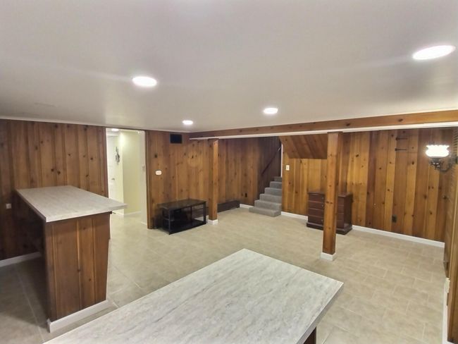 Finished below grade area with wooden walls, stairs, recessed lighting, and baseboards | Image 25