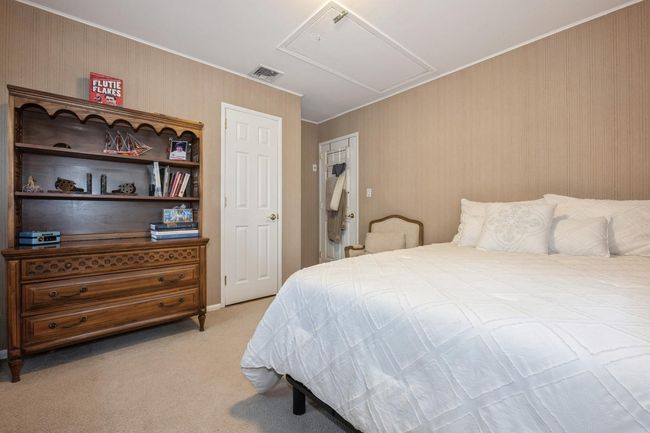 Bedroom with attic access, light colored carpet, visible vents, and crown molding | Image 15