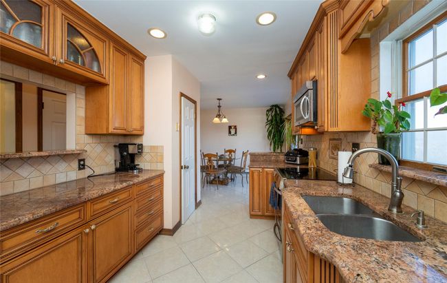 Kitchen featuring a sink, brown cabinets, a wealth of natural light, and stainless steel appliances | Image 21