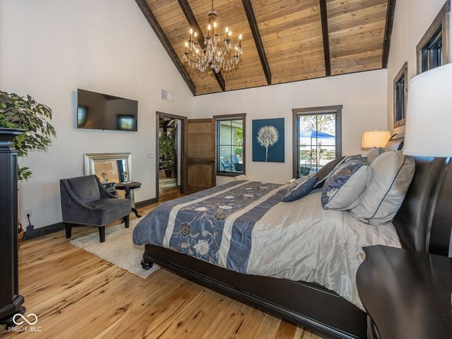 bedroom with wood ceiling with exposed beams, high vaulted ceiling, a chandelier, wood-type flooring, and baseboards | Image 19