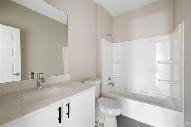 Full bathroom featuring toilet, vanity, shower / bath combination, and tile patterned floors | Image 12