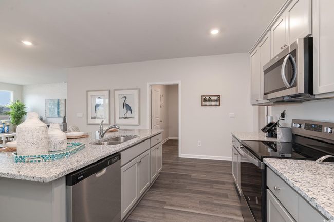 Kitchen with appliances with stainless steel finishes, a sink, dark wood-type flooring, baseboards, and recessed lighting | Image 4