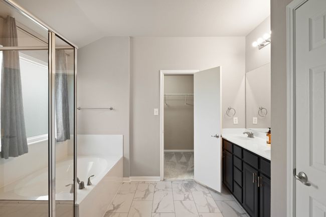 Full bath with a bath, double vanity, marble finish floors, a spacious closet, and a stall shower | Image 18