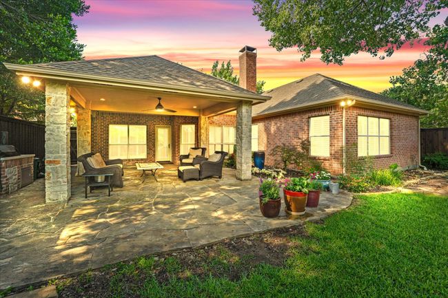Back of house at dusk with an outdoor living space, brick siding, a chimney, and a patio area | Image 28