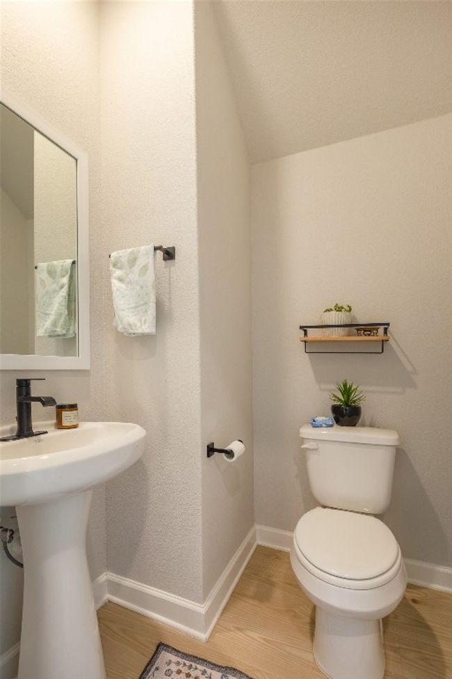 Half bath featuring wood finished floors and vaulted ceiling | Image 21