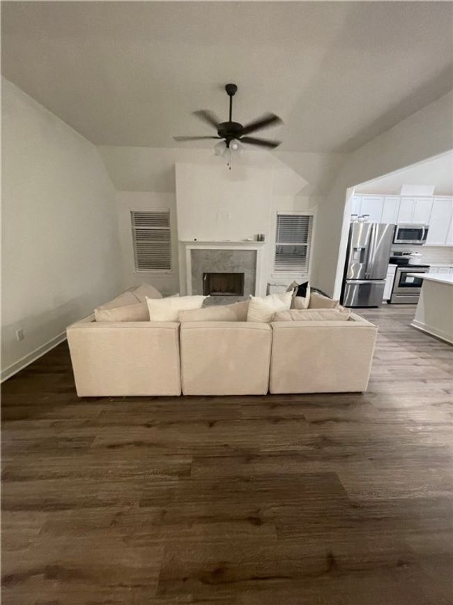 Living area featuring a ceiling fan, LVP floors, 10 foot ceiling, and a fireplace | Image 8