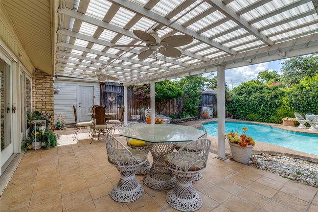 Fenced backyard featuring a pergola, outdoor dining space, a patio area, and ceiling fan | Image 23