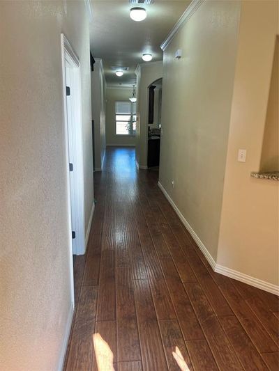 Hall with dark hardwood / wood-style floors and crown molding | Image 2