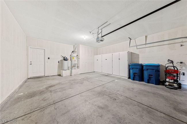Garage featuring secured water heater and a garage door opener | Image 30