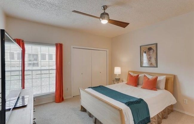 Carpeted bedroom featuring multiple windows, a textured ceiling, a ceiling fan, and a closet | Image 13