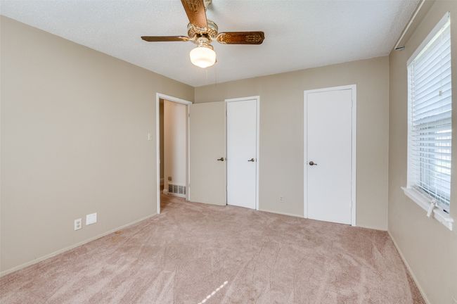 Unfurnished bedroom featuring ceiling fan, light colored carpet, and a textured ceiling | Image 18
