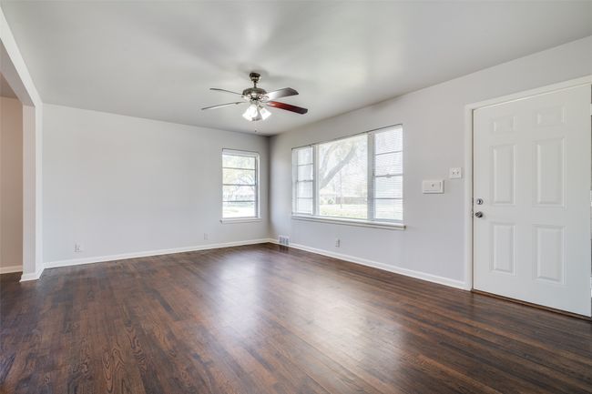 Unfurnished living room featuring dark wood-style flooring, ceiling fan, and baseboards | Image 4