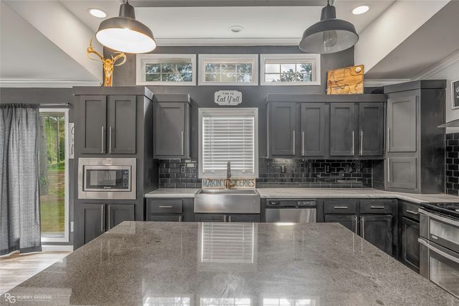Kitchen with tasteful backsplash, stainless steel appliances, crown molding, and a sink | Image 20