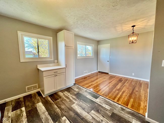 unfurnished dining area featuring visible vents, baseboards, and wood finished floors | Image 9