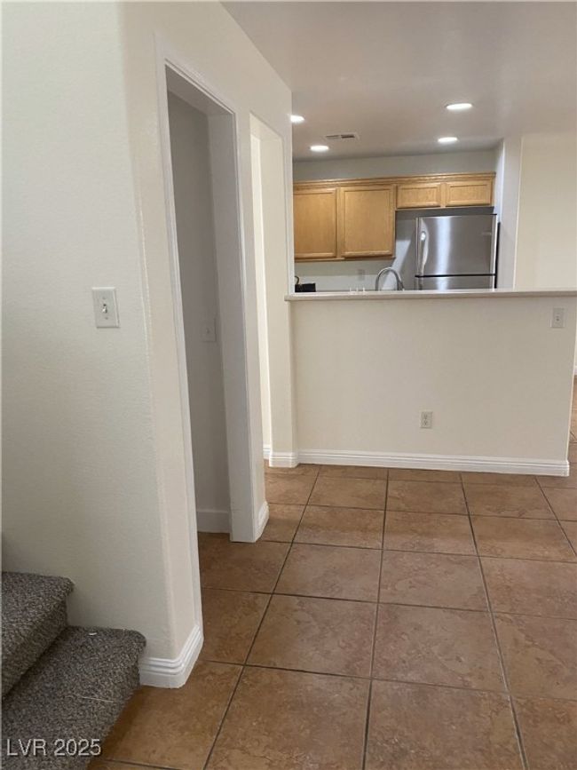 Kitchen with tile patterned floors, visible vents, recessed lighting, and freestanding refrigerator | Image 11