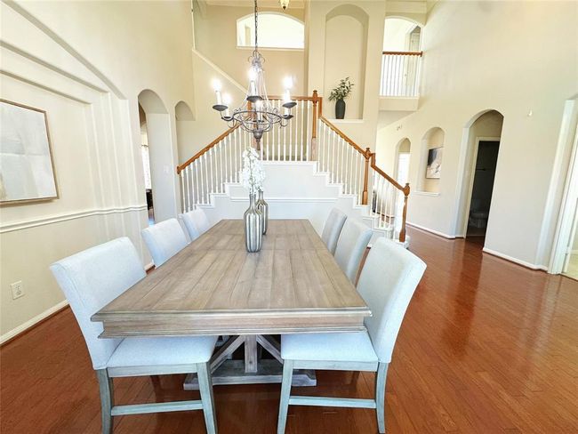 Elegant formal dining with chandelier and high ceilings. | Image 8