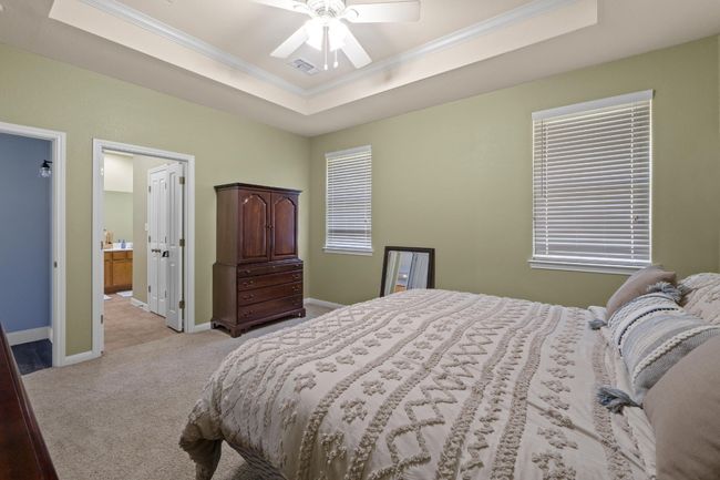 Bedroom featuring baseboards, crown molding, a tray ceiling. | Image 22