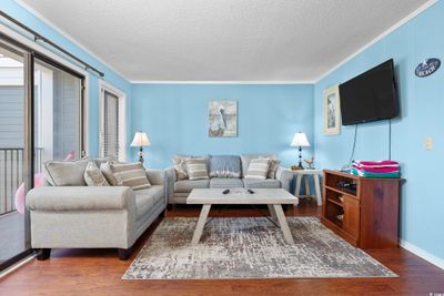 Living room with a textured ceiling, ornamental molding, and dark hardwood / wood-style floors | Image 2