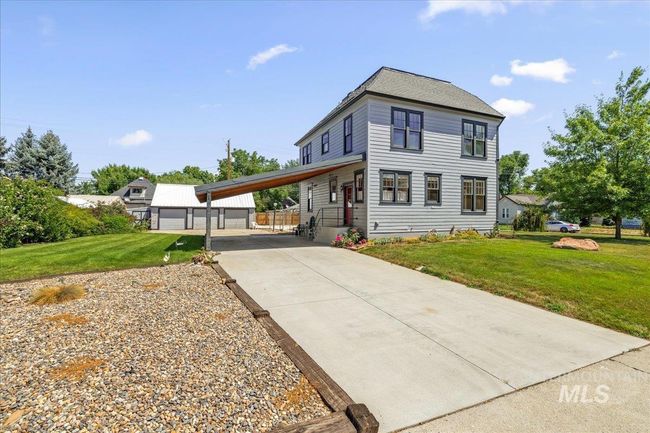 View of front facade featuring driveway, a front lawn, an outbuilding, and a carport | Image 8