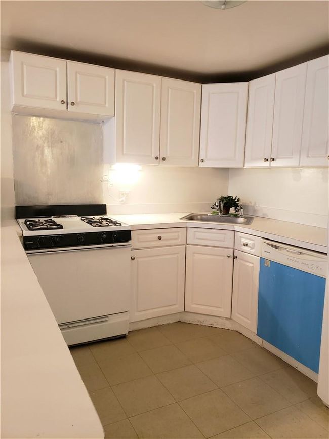 Kitchen with white cabinets, white appliances, and sink | Image 13