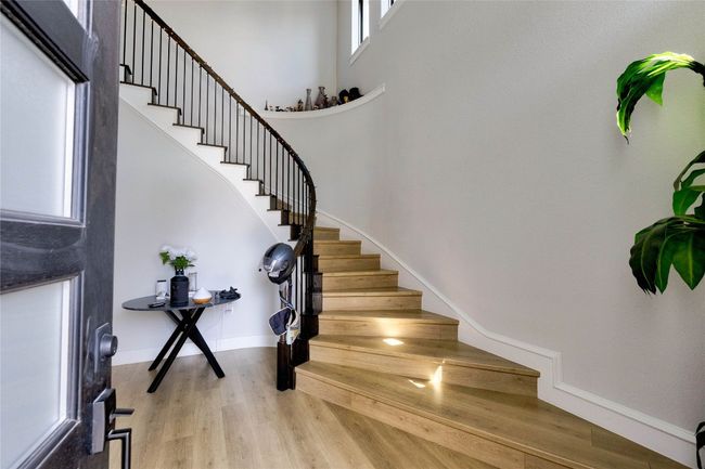 Stairway with a high ceiling, baseboards, and wood finished floors | Image 9