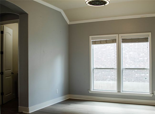 Spare room with crown molding, dark wood-style flooring, arched walkways, and vaulted ceiling | Image 20