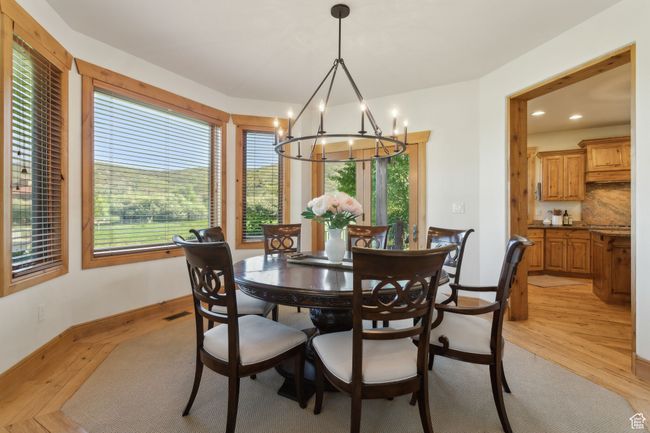 Dining room with a chandelier, light wood finished floors, baseboards, and recessed lighting | Image 8