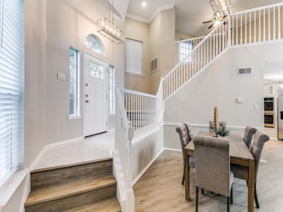 Dining space with light wood-type flooring, plenty of natural light, a high ceiling, and crown molding | Image 3