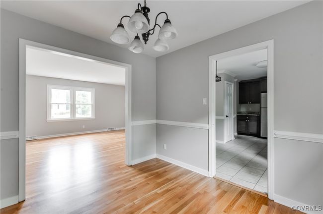 Unfurnished room with a chandelier and light wood-style floors | Image 6