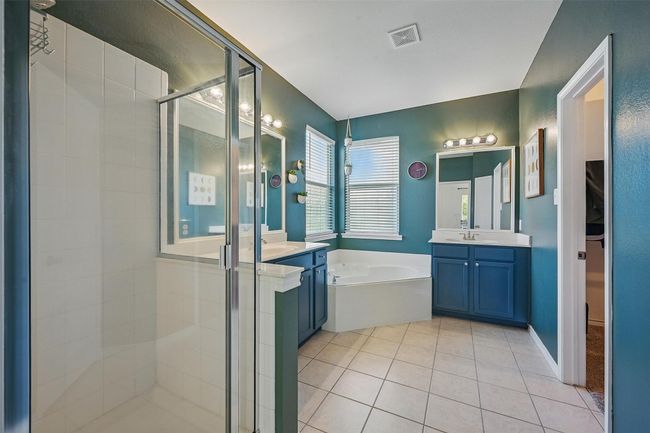 Bathroom featuring a stall shower, vanity, a bath, and tile patterned floors | Image 18