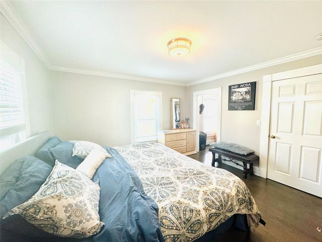 Bedroom with multiple windows, dark wood-type flooring, and crown molding | Image 10