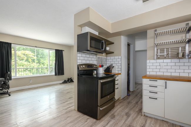 Kitchen featuring appliances with stainless steel finishes, wooden counters, light wood finished floors, backsplash, and open shelves | Image 13