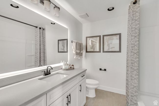 Full bath featuring vanity, a shower with curtain, and wood finished floors | Image 12