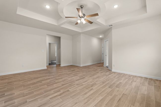 Spare room featuring a ceiling fan, coffered ceiling, baseboards, recessed lighting, and light wood-style floors | Image 6