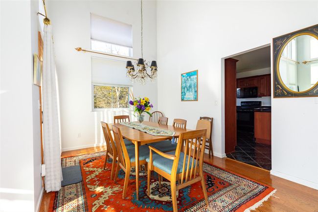 Dining space with a towering ceiling, hardwood / wood-style flooring, and an inviting chandelier | Image 14