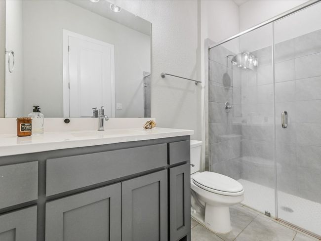 Bathroom featuring vanity, a shower stall, and tile patterned flooring | Image 31