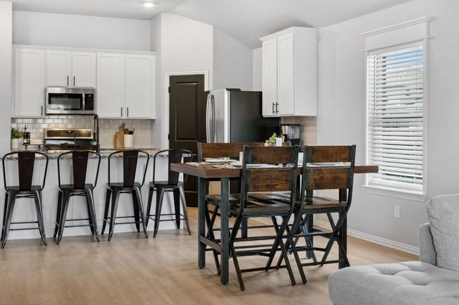 The kitchen seamlessly transitions to a dining area. | Image 11