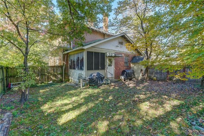 Rear view of property featuring a fenced backyard, a lawn, and brick siding | Image 26