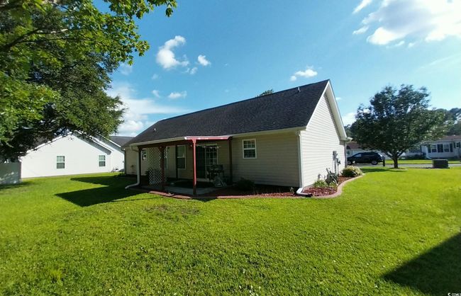 Rear view of house with a lawn, a patio, and roof with shingles | Image 13