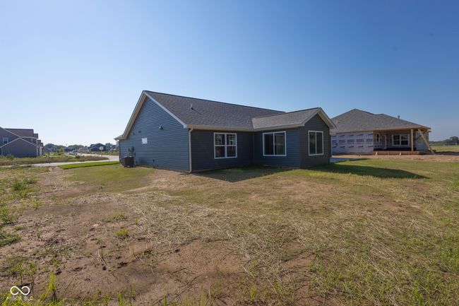 rear view of property with a yard and roof with shingles | Image 6