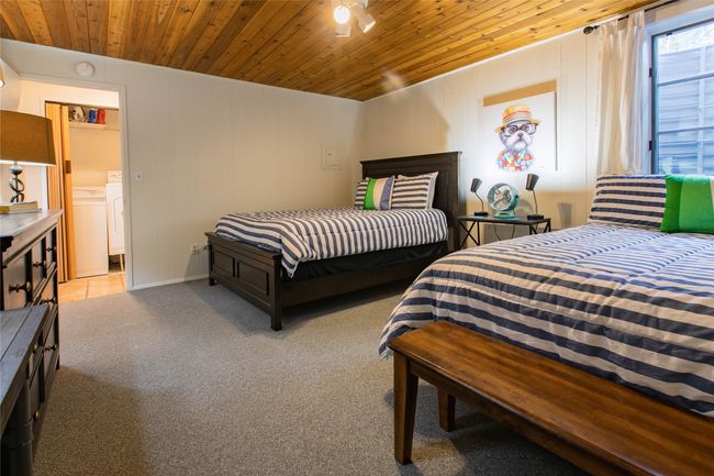 Bedroom featuring carpet flooring, separate washer and dryer, and wooden ceiling | Image 12
