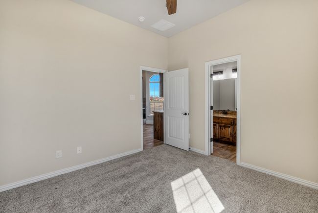 Unfurnished bedroom with carpet, baseboards, ensuite bath, and ceiling fan | Image 32