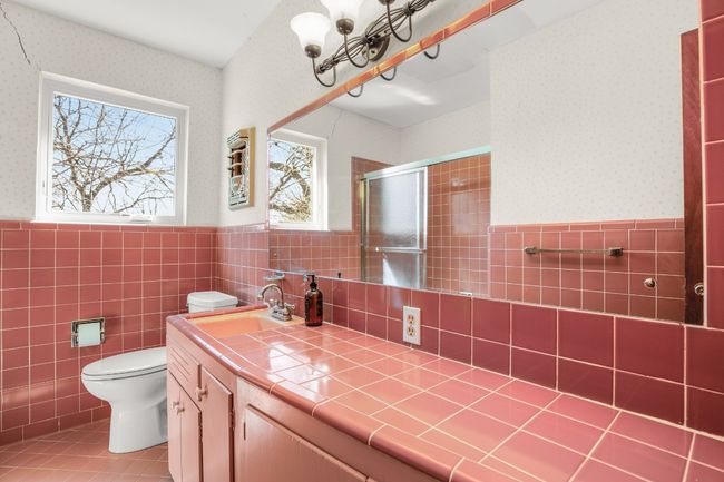 Bathroom with a wainscoted wall, wallpapered walls, a shower stall, vanity, and tile patterned floors | Image 26