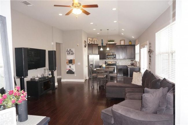Living room with ceiling fan, dark wood finished floors, vaulted ceiling, and recessed lighting | Image 4