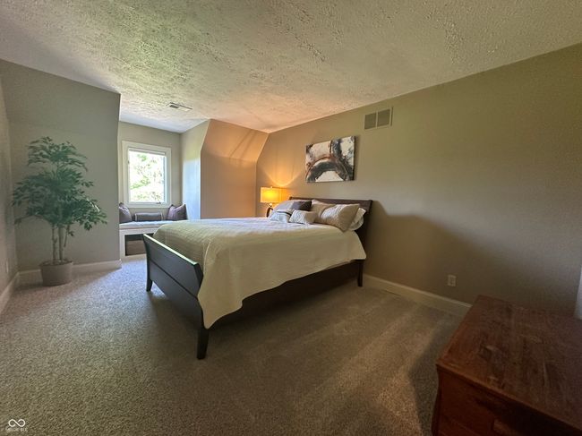 carpeted bedroom featuring a textured ceiling and baseboards | Image 32