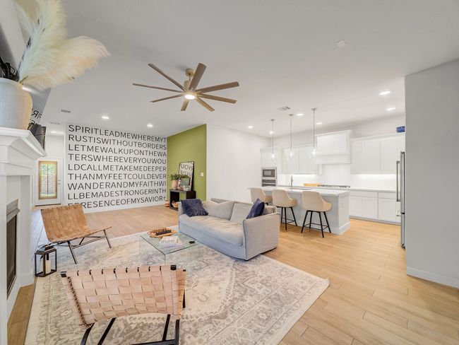 Living room featuring light wood-style flooring, ceiling fan, a fireplace, and recessed lighting | Image 7