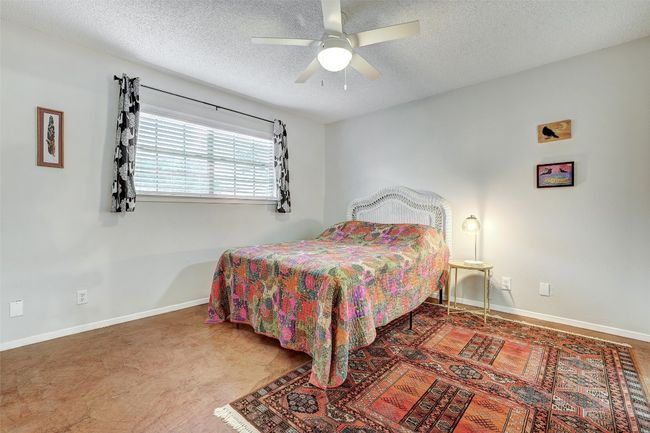 Bedroom featuring a textured ceiling, baseboards, and ceiling fan | Image 16