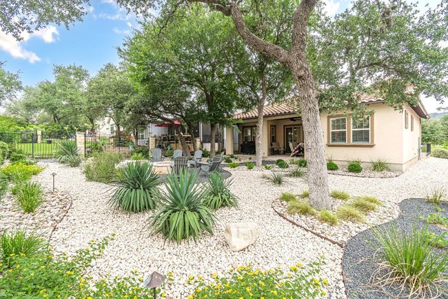 Rear view of house with stucco siding, a tiled roof, and a patio area | Image 38